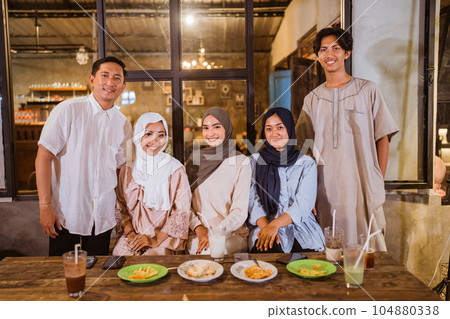 a group of Muslim friends smile at the camera while gathering a group of Muslim friends smile at the camera while gathering 104880338