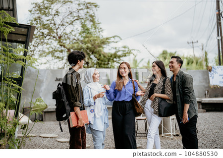 Asian student group stands up while hanging out at outdoor coworking space 104880530