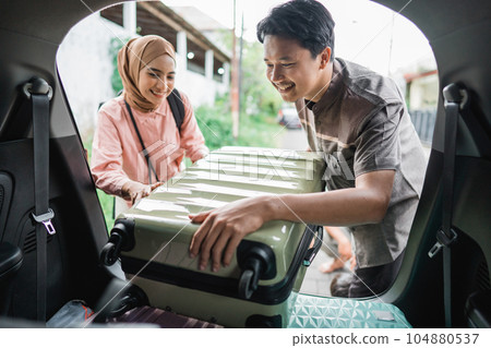 muslim couple packing suitcase in the car muslim couple packing suitcase in the car 104880537