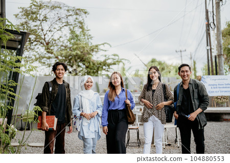 smiling group of Asian students standing in an outdoor coworking space 104880553