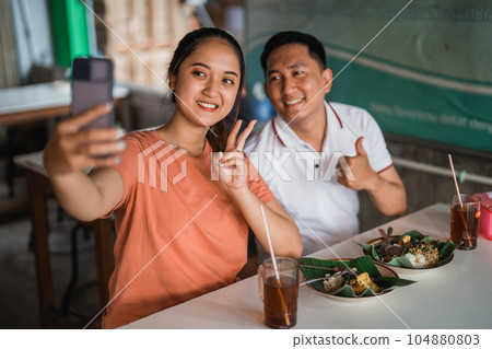 dating woman and man take a selfie while eating together dating woman and man take a selfie while eating together 104880803
