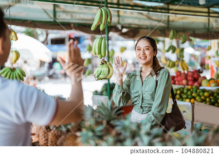 female customer smiling and waving her hands to her friend female customer smiling and waving her hands to her friend 104880821