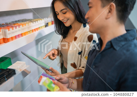 female shopekeeper pointing on the digital tablet female shopekeeper pointing on the digital tablet 104880827