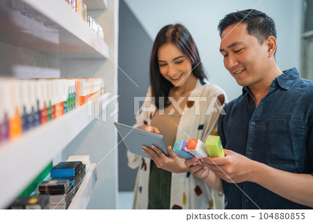 couple of vape store keeper using the digital tablet couple of vape store keeper using the digital tablet 104880855