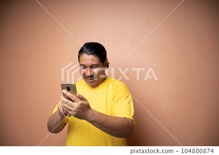 old asian man holding handphone and using it to communicate old asian man holding handphone and using it to communicate 104880874