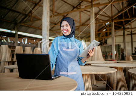 young businesswoman in veil standing using a tablet and laptop computer young businesswoman in veil standing using a tablet and laptop computer 104880921