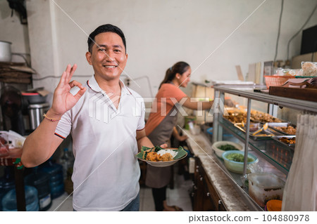 male customer with okay gesture carrying a plate of pecel male customer with okay gesture carrying a plate of pecel 104880978