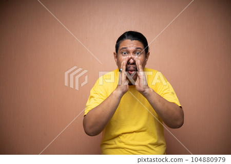 old asian man with whispered hand gesture in plain background old asian man with whispered hand gesture in plain background 104880979