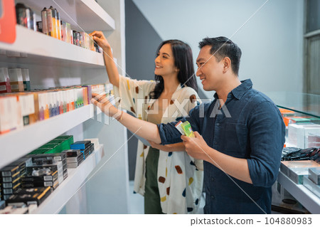 couple of vape seller observing the liquid 104880983