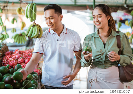 couple of asian customer choosing the avocados 104881007