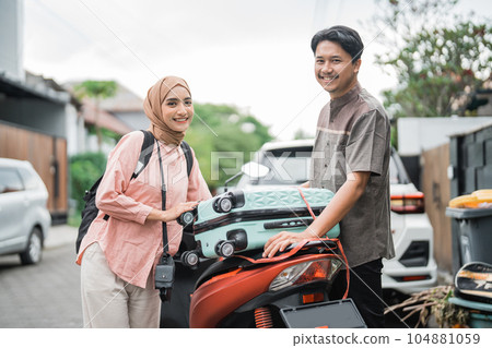 male muslim pack his suitcase on his motorbike getting ready to travel during eid mubarak male muslim pack his suitcase on his motorbike getting ready to travel during eid mubarak 104881059