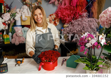 Smiling woman florist flower shop owner hold roses composition ready to sell on store background Smiling woman florist flower shop owner hold roses composition ready to sell on store background 104881152