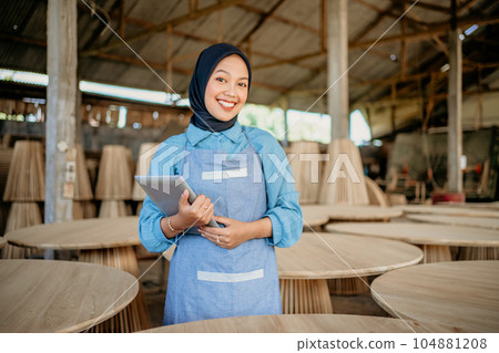 smiling woman in veil with holding a tablet 104881208
