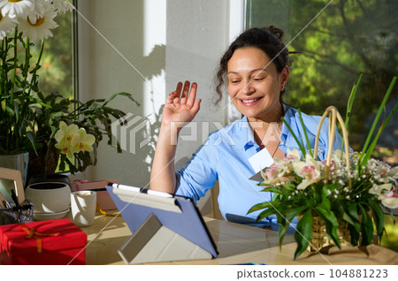 Smiling woman, floral designer discussing the design of flower arrangements for festive life events in a flower shop 104881223