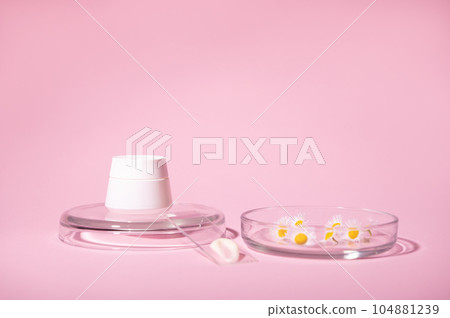 White stylish mockup jar and chamomile flowers in Petri dish and lab glass with a swatch of moisturizer, pink background White stylish mockup jar and chamomile flowers in Petri dish and lab glass with a swatch of moisturizer, pink background 104881239