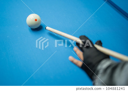 hand of the male player with black glove poking the white ball hand of the male player with black glove poking the white ball 104881241