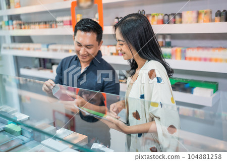 couple of shopkeeper checking the stock of vape mod couple of shopkeeper checking the stock of vape mod 104881258