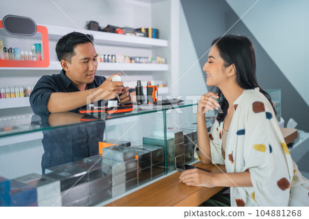 male vape seller helping the female customer to refill the e liquid male vape seller helping the female customer to refill the e liquid 104881268
