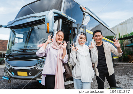 three young traveler smile showing thumb in front of the bus three young traveler smile showing thumb in front of the bus 104881277