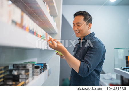 male seller observing the e liquid male seller observing the e liquid 104881286