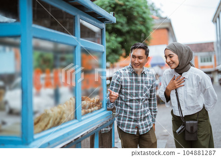 man and woman while shopping on street food vendor man and woman while shopping on street food vendor 104881287