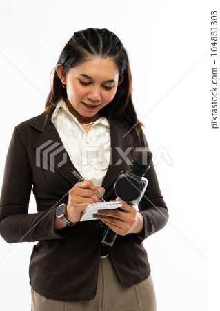 a beautiful journalist writing on the notebook at her hand a beautiful journalist writing on the notebook at her hand 104881303