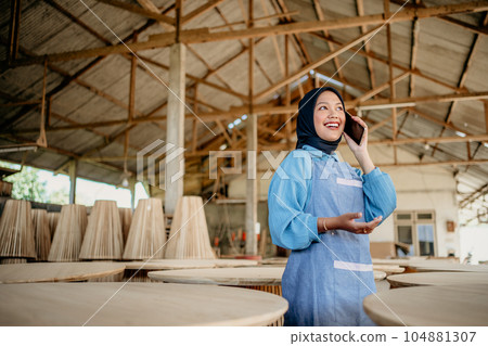 veiled Asian entrepreneur using a mobile phone call to work veiled Asian entrepreneur using a mobile phone call to work 104881307