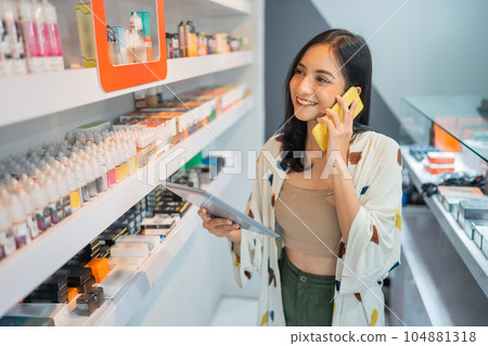 female vape seller calling on phone while checking the liquid stock female vape seller calling on phone while checking the liquid stock 104881318