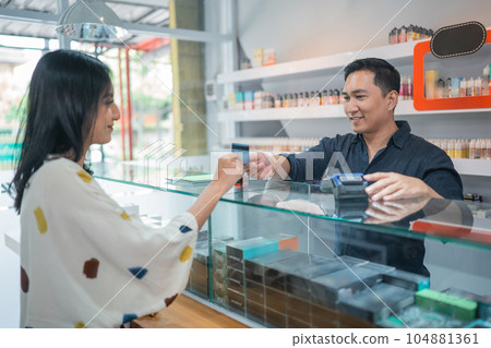female customer paying the stuff using the credit card female customer paying the stuff using the credit card 104881361
