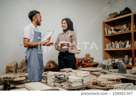Male shop assistant serving a Muslim female customer during a chat Male shop assistant serving a Muslim female customer during a chat 104881367
