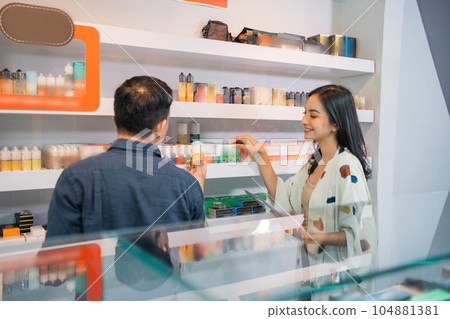 couple of shopkeeper checking the stock of the liquids couple of shopkeeper checking the stock of the liquids 104881381