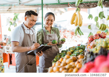 the male fruit seller writing on the clipboard the male fruit seller writing on the clipboard 104881387