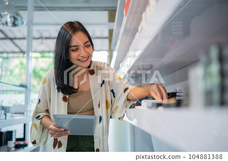 asian shopkeeper smiling while arranging the vape mods stock asian shopkeeper smiling while arranging the vape mods stock 104881388