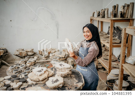 side view of Muslim businesswoman smile holding a stone craft side view of Muslim businesswoman smile holding a stone craft 104881395
