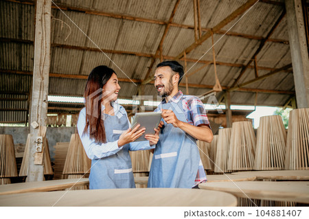 Asian enterpreneur couple chatting while working on a tablet together Asian enterpreneur couple chatting while working on a tablet together 104881407