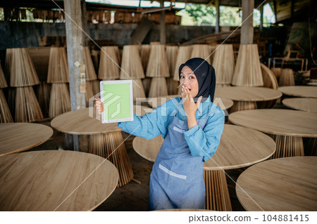 asian veiled businesswoman shows tablet screen while covering her mouth asian veiled businesswoman shows tablet screen while covering her mouth 104881415