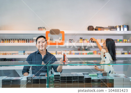 male seller standing put the vape mod on the display table 104881423