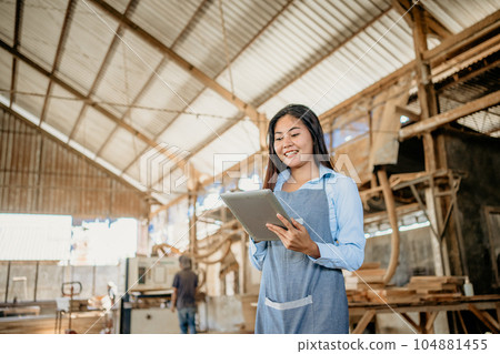 Female entrepreneur wearing apron while working with digital tablet Female entrepreneur wearing apron while working with digital tablet 104881455