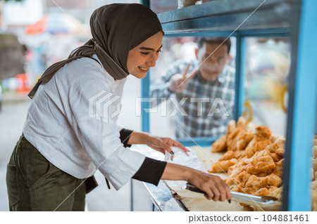woman in hijab sell traditional street food woman in hijab sell traditional street food 104881461