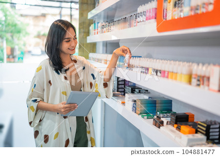 beautiful shopkeeper observing the liquid stock beautiful shopkeeper observing the liquid stock 104881477