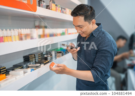 male vape seller taking photo of the liquid stock male vape seller taking photo of the liquid stock 104881494