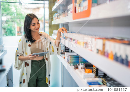 female seller checking the liquid stock at the shelf female seller checking the liquid stock at the shelf 104881537