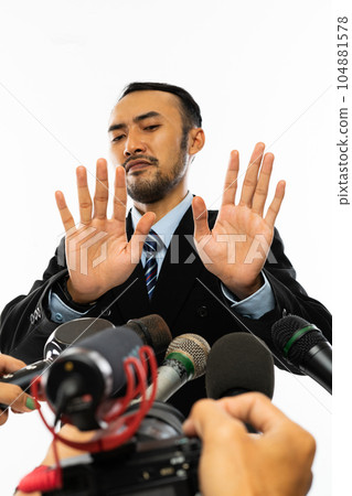 a handsome man dodged when proffered by many microphone 104881578