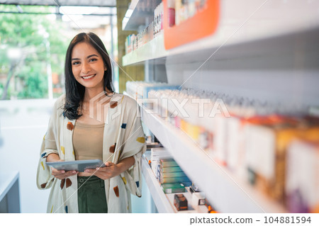 smiling vape seller standing beside the store shelf smiling vape seller standing beside the store shelf 104881594