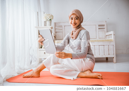 muslim hijab woman watching home work out tutorial from tablet muslim hijab woman watching home work out tutorial from tablet 104881667