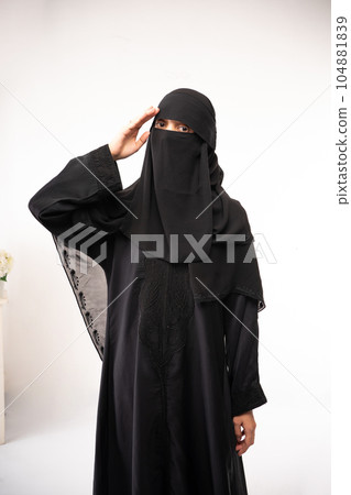 muslim woman wearing a black hijab and long dress salute. muslim woman wearing a black hijab and long dress salute. 104881839