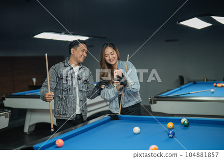 male pool player pointing on the phone male pool player pointing on the phone 104881857