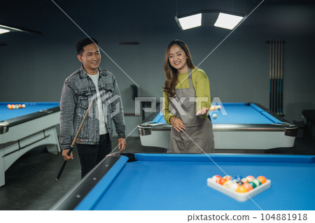 pool table worker helps player arranging the balls with triangle rack pool table worker helps player arranging the balls with triangle rack 104881918