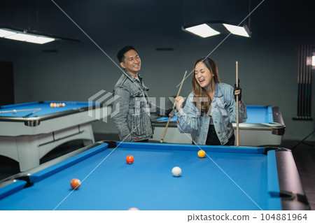 excited female pool player clenched her arm while playing the billiard 104881964