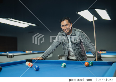 the male pool player smiling to the camera the male pool player smiling to the camera 104881968
